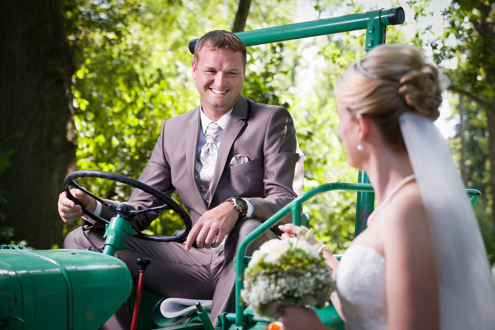 Bräutigam auf Traktor beim Fotoshooting - Hochzeit in Finningen